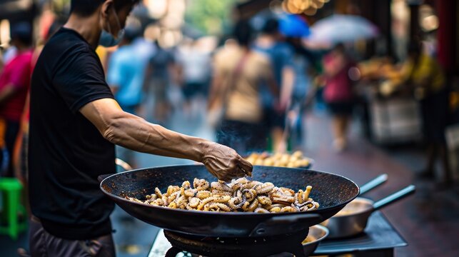 Vendor frying crispy saltandpepper squid Jiao yan you yu on a busy street food corner