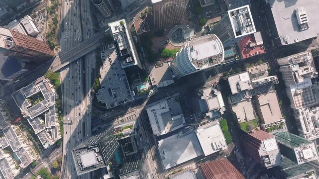 The bustling metropolitan life of Downtown LA, California is showcased in this aerial photograph, featuring skyscrapers, roads, and modern infrastructure under the sunny urban sky
