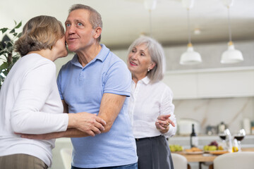 Couple of elderly man and elderly woman talking in kitchen at home