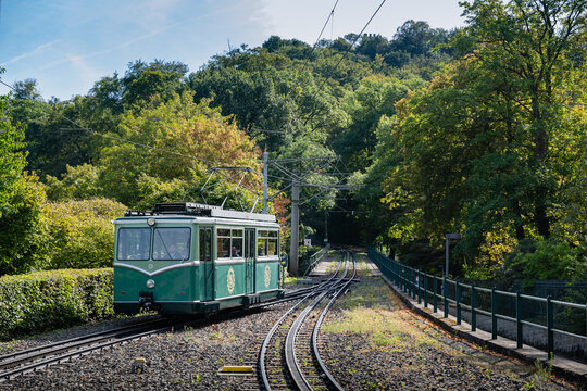 A historic train passing through the scenic railway in Drachenfels, surrounded by lush greenery and natural beauty, highlighting the charm of countryside exploration.