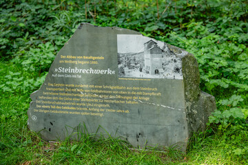 Historical sign at the basalt quarry site in the Siebengebirge forest, detailing the extraction...