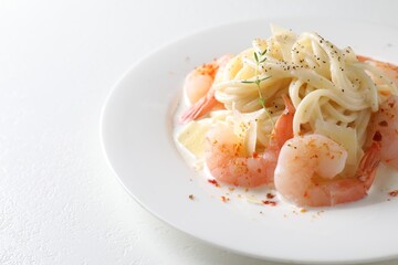 Delicious pasta with shrimps and cheese on white table, closeup