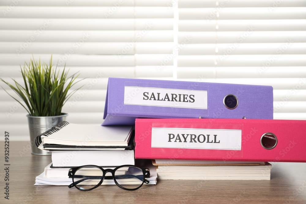 Wall mural office folders with words payroll and salaries, houseplant, glasses and stationery on wooden table