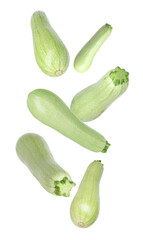 Fresh raw zucchinis falling on white background