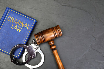 Book Criminal Law, judge's gavel and handcuffs on grey table, flat lay