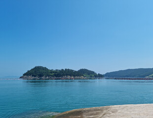It is a blue seascape with an island visible.