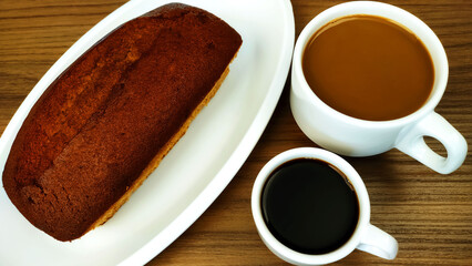 Cup of latte or coffee with milk also known as pingado in Brazil and cup of coffee on wooden table.
