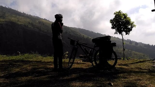Silhouette of a man prepare riding a mountain bike with pannier rack