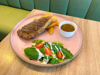 Grilled Steak with Fries, Salad, and Gravy on a Pink Plate