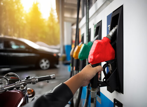 Motorcycle Biker hand pulling  being filled up at a fuel pump for biofuel energy for classic touring hobbies