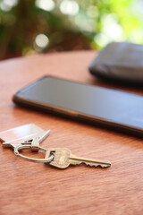 A smartphone along with keys placed on a beautifully crafted wooden table surface