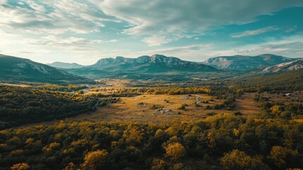 A nature landscape with a mountain range in the distance, captured from a drone's perspective. The drone's camera captures the rugged beauty of the mountains and the surrounding wilderness,