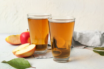 Glasses of fresh apple juice on light blue table