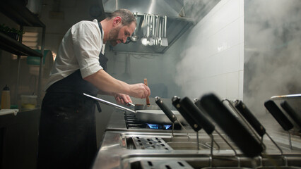 Chef Turning On The Stove Under The Pan