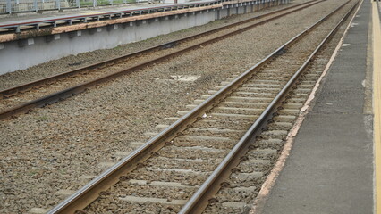 Gravel is around the train track which serves to dampen vibrations or shocks when the train passes through the tracks
