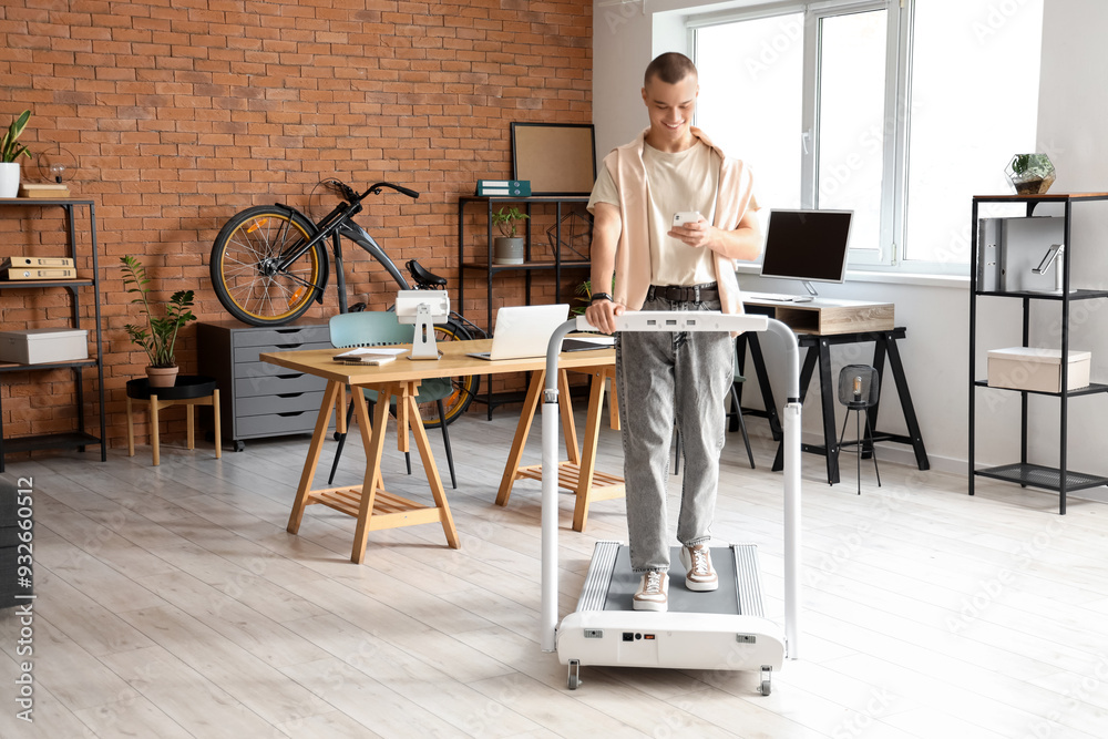 Sticker young businessman talking by mobile phone on treadmill in office