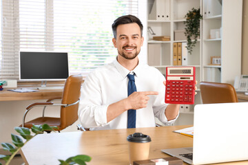 Male accountant pointing at calculator in office