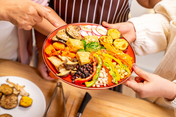 Group of Happy Asian senior women having dinner together at home. Elderly retired woman friends enjoy healthy lifestyle cooking and making vegan food vegetables salad with tofu together in the kitchen
