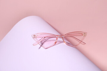 Stylish pink sunglasses on colorful background