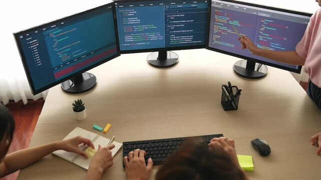 Slow motion back end software developer engineer for computer programming working together on debugging writing computing code, solving complex algorithms display on monitor in office. Burgeoning