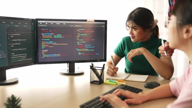 Slow motion back end software developer engineer for computer programming working together on debugging writing computing code, solving complex algorithms display on monitor in office. Burgeoning