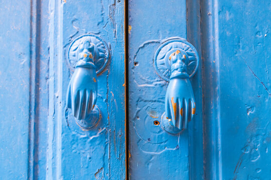 Hammamet, Nabeul, Tunisia. Hand shaped door knockers on a blue painted door.