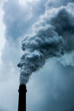 China, Chongqing, Steam and smoke billows from smokestacks at massive coal-fired power plants on cloudy autumn afternoon