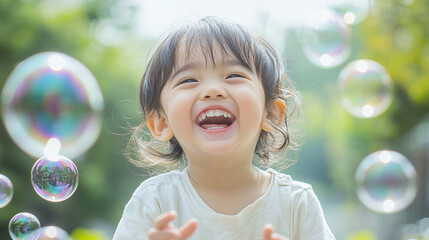 Asian child laughing while playing with bubbles