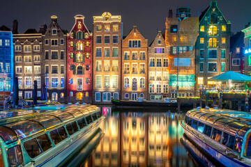 Old houses of Amsterdam. The houses stand in the water and have a beautiful reflection. Touristic district Damrak. These houses are famous all over the world. Amsterdam, Holland, Europe