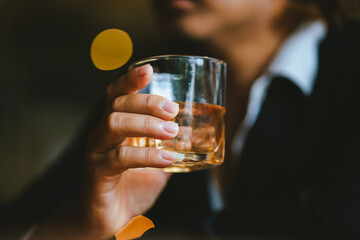A young businessman holds a glass of whiskey, toasting with friends at an upscale bar. The scene captures the essence of luxury and celebration, with a focus on camaraderie and the nightlife atmospher