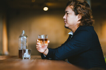 A young businessman holds a glass of whiskey, toasting with friends at an upscale bar. The scene captures the essence of luxury and celebration, with a focus on camaraderie and the nightlife atmospher