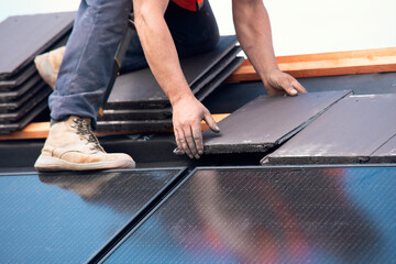 Worker Installing Solar Panels on  Rooftop in Bright Daylight