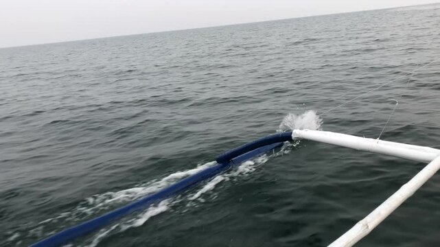 First-person view of the sea from a sailing boat whose outriggers banging against the waves
