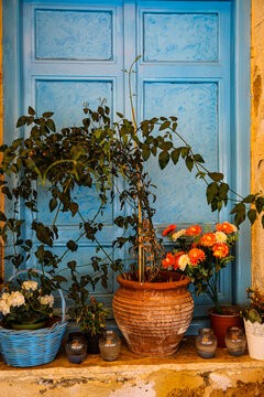 Greece. Blue wall and flower basket with terra cotta pot and flowers