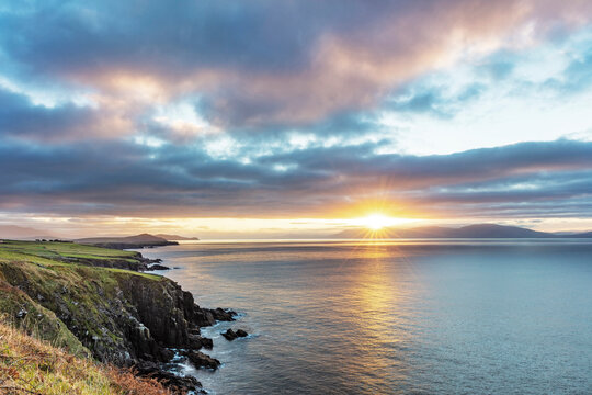 Sunrise over Dingle Bay as fishing boats heads out in County Kerry, Dingle, Ireland