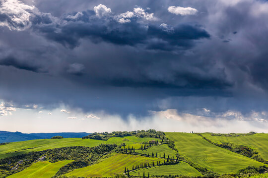 Europe, Italy, Val d' Orcia. Storm clouds over Tuscany landscape. 