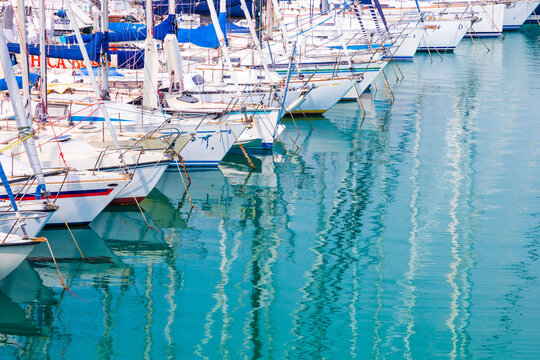 White sailboats in blue water.