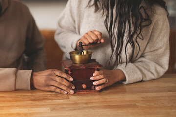 Couple Grinding Coffee Beans Together in Cozy Kitchen Setting on Wooden Table