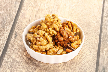 Cracked unshelled walnut in the bowl
