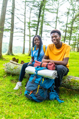 Fototapeta premium Friends smiling sitting on a log in a beauty forest