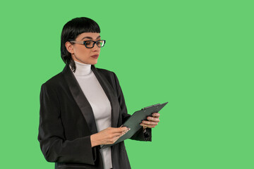 Businesswoman Reviewing Notes in  Studio With Green Background