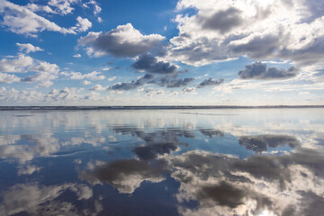 The stunning view of the sky beautifully mirrored in the tranquil waters of Costa Rica, showcasing a glorious array of vibrant clouds and an incredibly serene atmosphere that enchants all