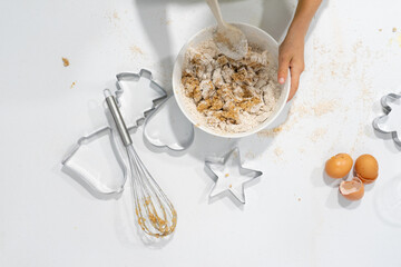 Bowl with homemade cookie dough seen from above and some Christmas shape molds to make Christmas cookies with copy space. Child cooking christmas cookies