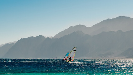 two windsurfers ride on the background of high rocky mountains in Egypt Dahab South Sinai