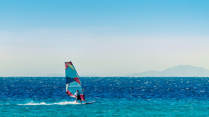 windsurfer on the background of high mountains rides on the waves of the Red Sea in Egypt Dahab...