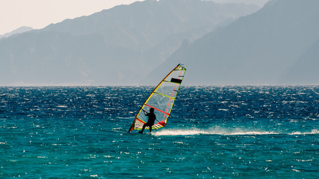 windsurfer on the background of high mountains rides on the waves of the Red Sea in Egypt Dahab South Sinai