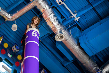 happy teenage girl with belay during training in climbing gym. 