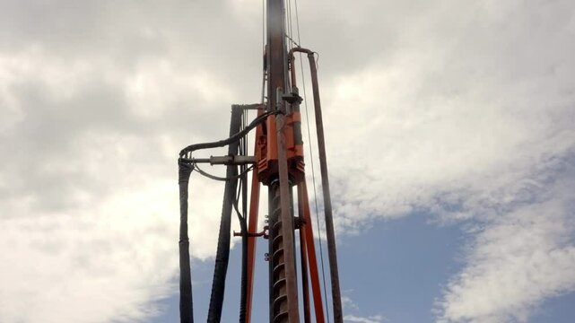Drilling Machine Operating in Field Under a Cloudy Sky
