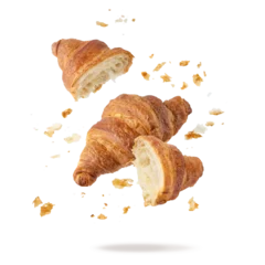 Fresh baked butter breakfast croissants and crumbs falling flying isolated on white background. Whole and broken in half croissants.