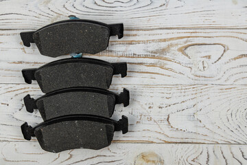 Disc brake shoes on a white wooden background. Top view